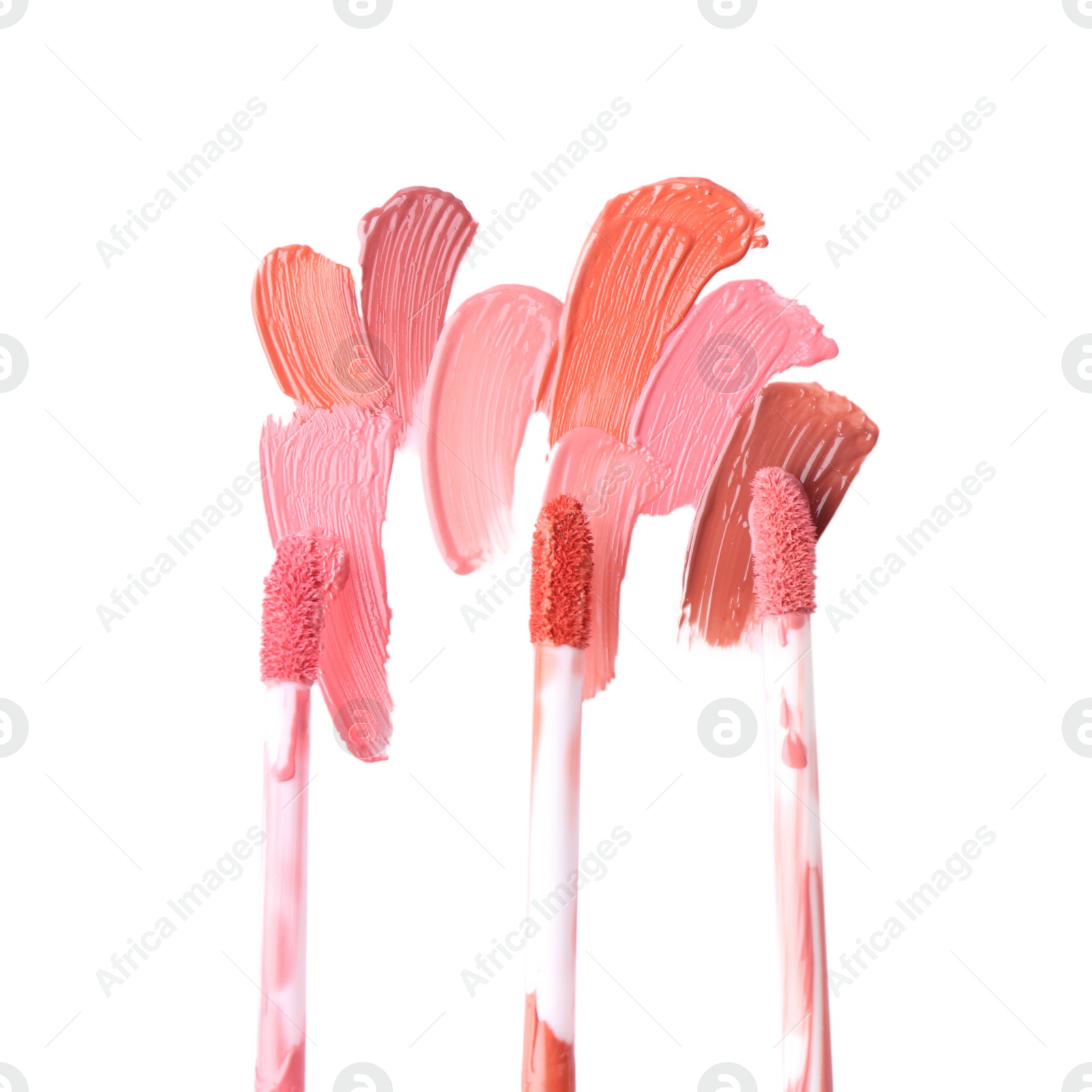 Photo of Strokes of different lip glosses and applicators isolated on white, top view