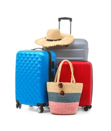 Packed suitcase with hat and hand-luggage on white background