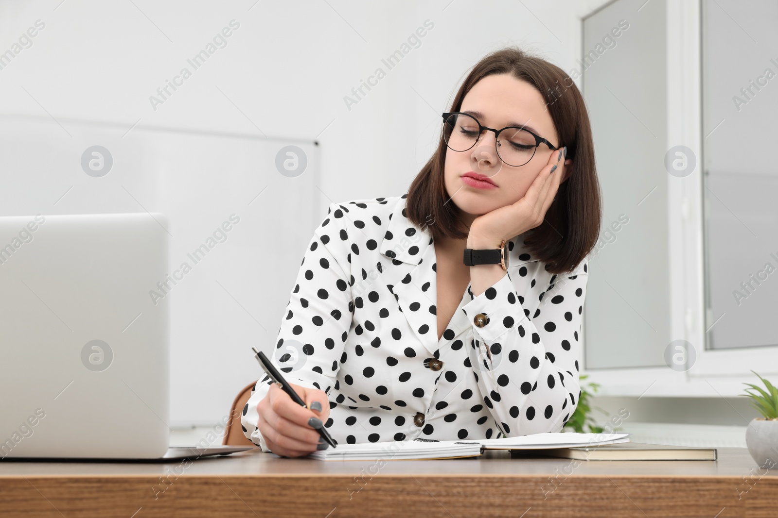Photo of Young intern working at table in modern office