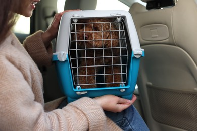 Photo of Woman with pet carrier travelling with dog her by car, closeup