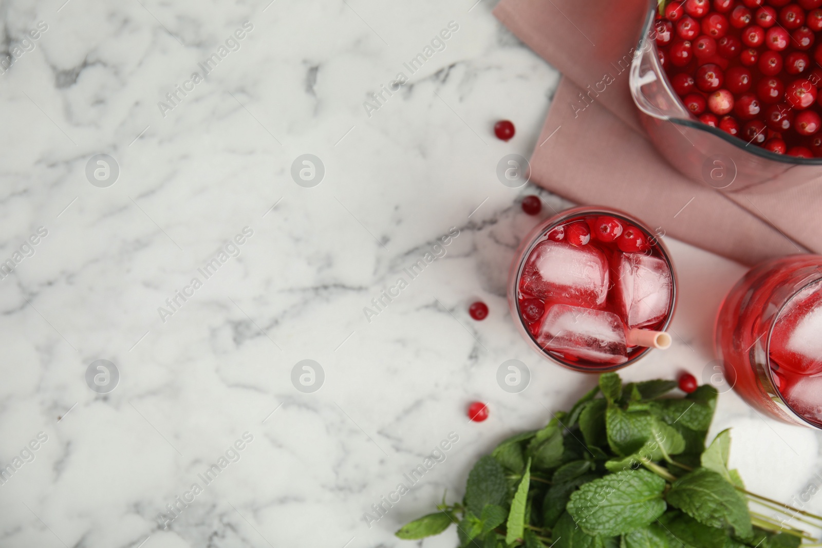 Photo of Tasty refreshing cranberry cocktails on white marble table, flat lay. Space for text