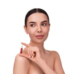 Beautiful young woman holding skincare ampoule on white background