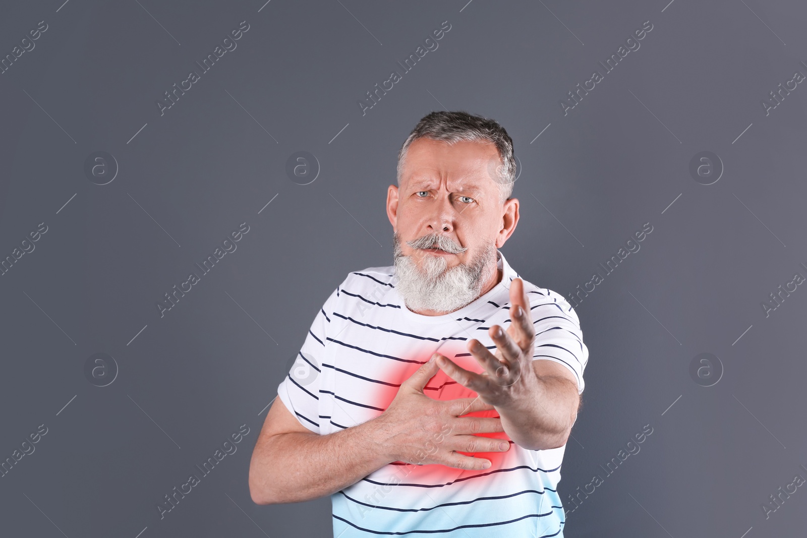 Photo of Mature man having heart attack on gray background