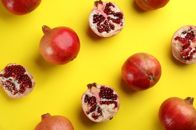 Photo of Flat lay composition with ripe pomegranates on yellow background