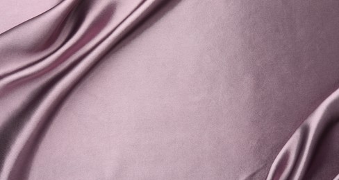 Photo of Crumpled dark purple silk fabric as background, top view. Space for text