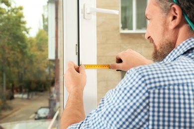 Photo of Man installing new modern window in house