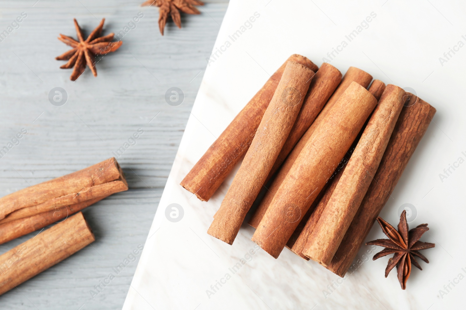 Photo of Aromatic cinnamon sticks and anise on marble board