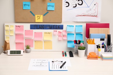 Business process planning and optimization. Workplace with colorful paper notes and other stationery on white wooden table