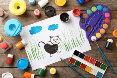 Photo of Flat lay composition with child's painting of cat on table
