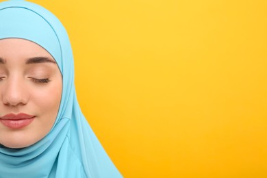 Muslim woman in hijab on orange background, closeup. Space for text