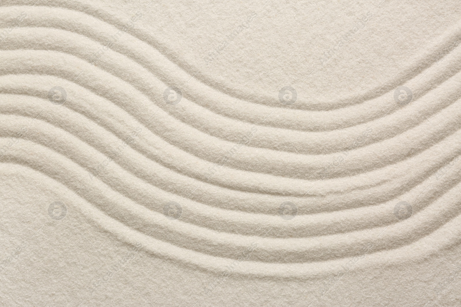 Photo of White sand with pattern as background, top view. Zen concept