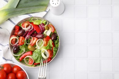 Photo of Bowl of tasty salad with leek and olives served on white tiled table, flat lay. Space for text