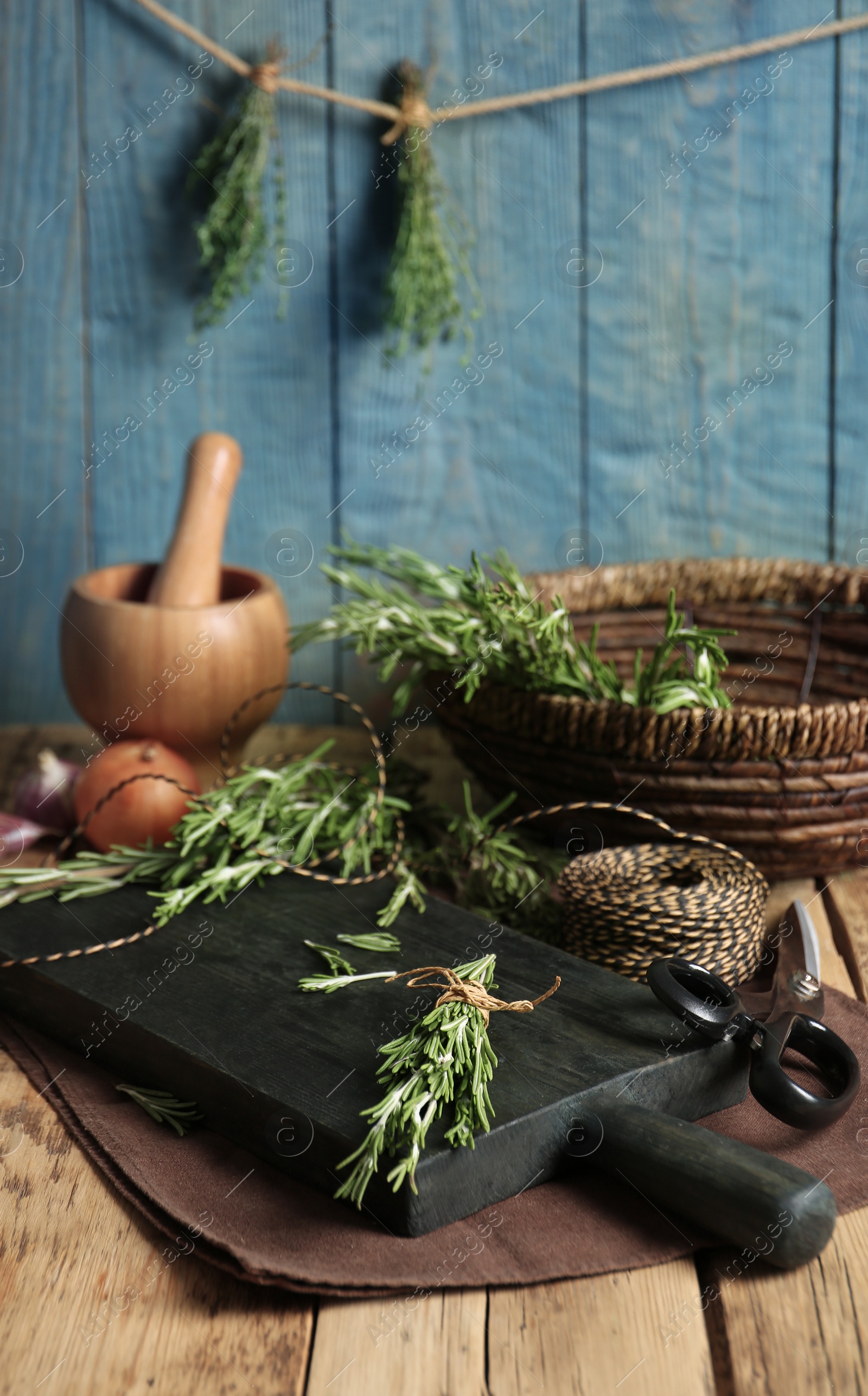 Photo of Wooden board with rosemary on table. Aromatic herbs