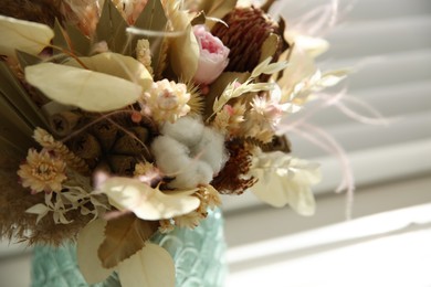 Photo of Beautiful dried flower bouquet in glass vase on windowsill, closeup