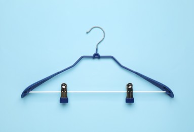 Empty hanger on light blue background, top view