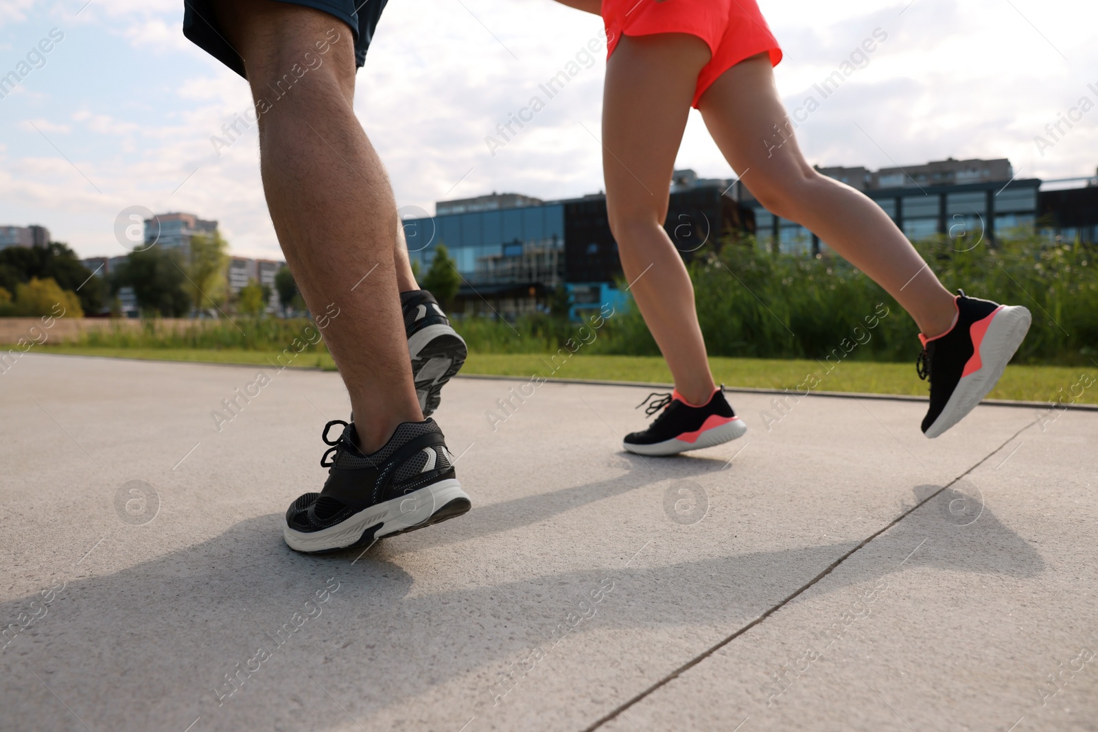 Photo of Healthy lifestyle. Couple running outdoors, closeup view