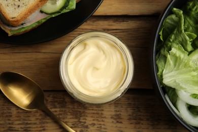 Photo of Flat lay composition with jar of delicious mayonnaise on wooden table