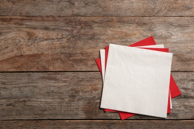 Photo of Clean napkins on wooden background, top view with space for text