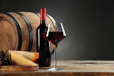 Winemaking. Composition with tasty wine and barrel on wooden table against dark background, space for text