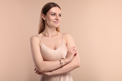 Photo of Beautiful woman with elegant jewelry on beige background