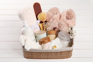 Photo of Spa gift set in wicker basket on white wooden table