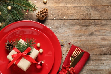 Beautiful Christmas table setting on wooden background, top view. Space for text