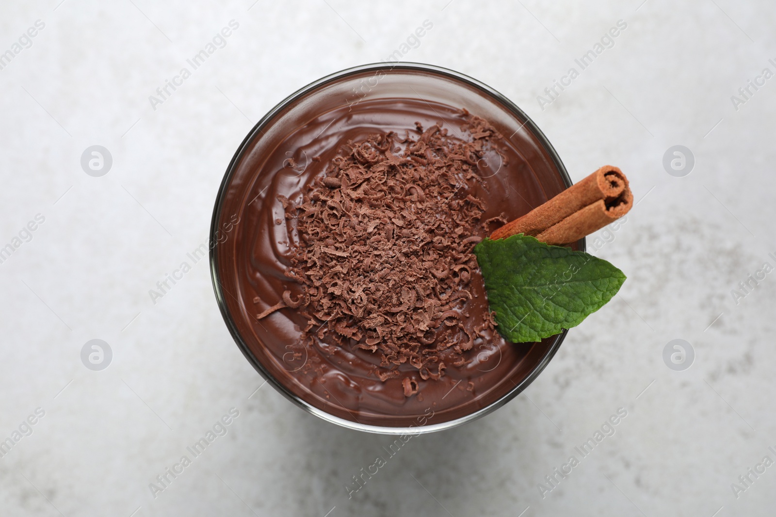 Photo of Cup of delicious hot chocolate with cinnamon stick and mint on light grey table, top view