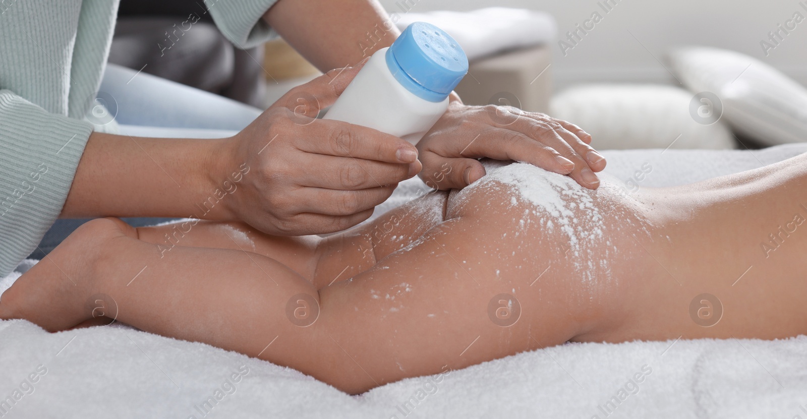 Image of Mother applying dusting powder on her baby at home, closeup. Banner design