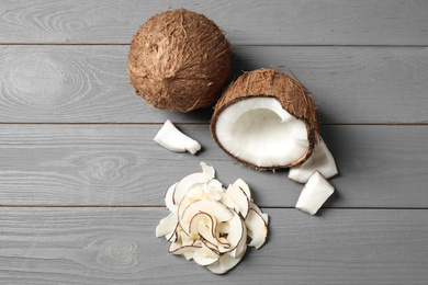 Photo of Flat lay composition with tasty coconut chips on grey wooden table