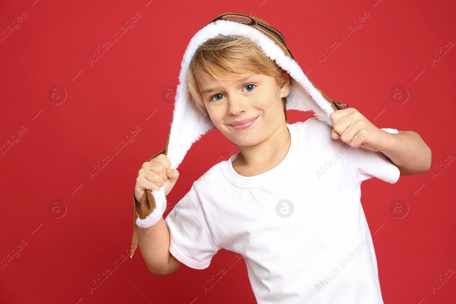 Photo of Cute little boy wearing hat on red background