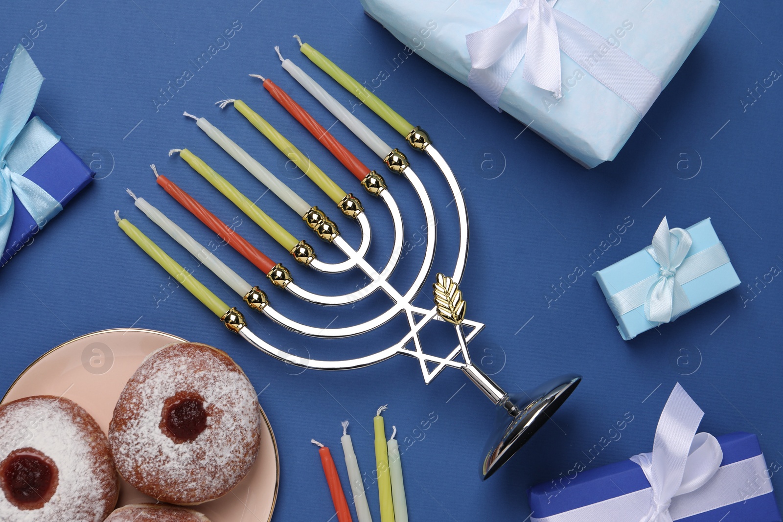 Photo of Flat lay composition with Hanukkah menorah and gift boxes on blue background