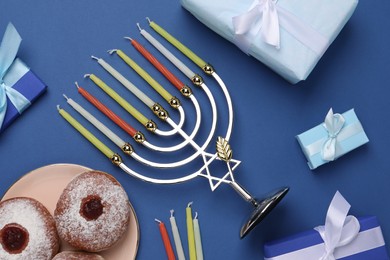 Flat lay composition with Hanukkah menorah and gift boxes on blue background