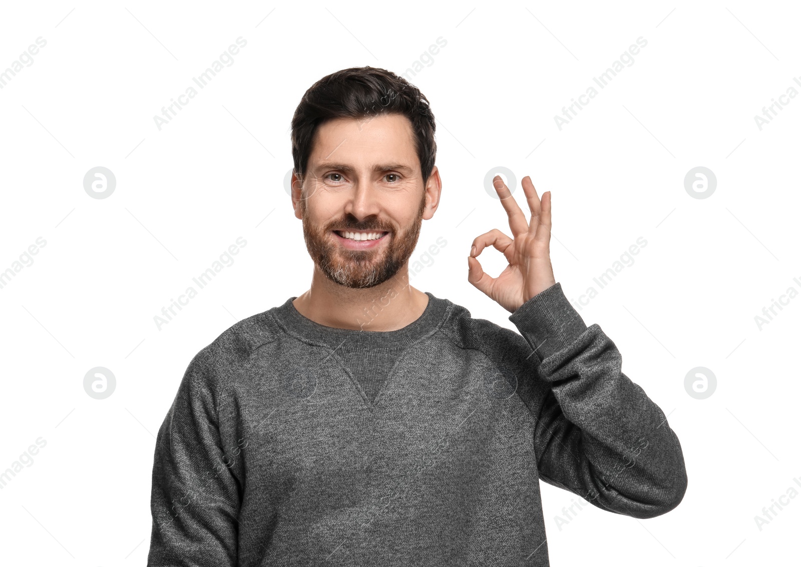 Photo of Smiling man with healthy clean teeth showing ok gesture on white background