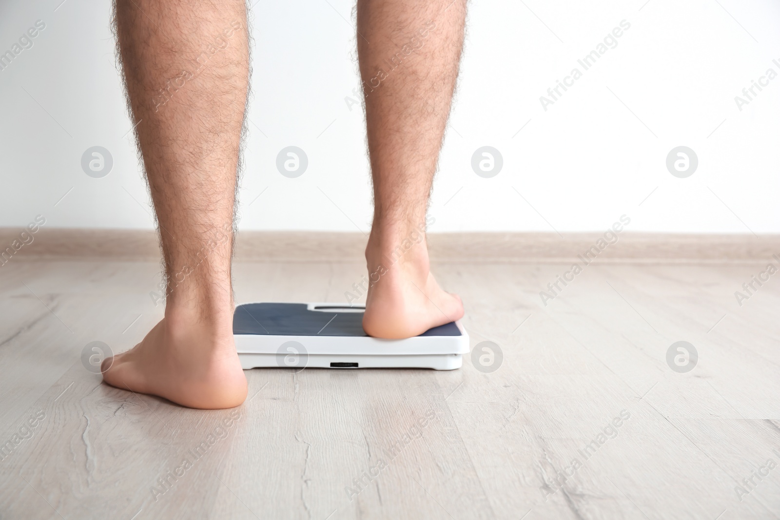 Photo of Overweight man measuring his weight indoors