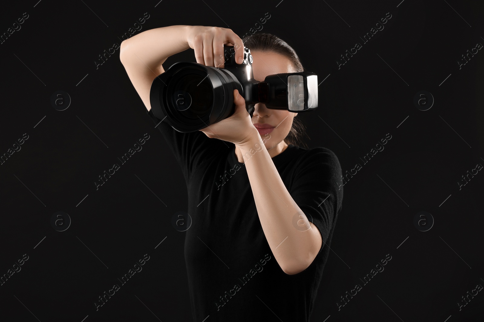 Photo of Professional photographer taking picture on black background