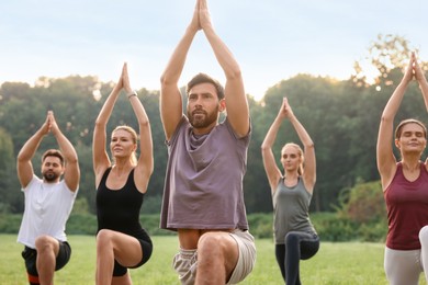 Photo of Group of people practicing yoga in park