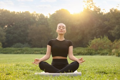 Photo of Beautiful woman practicing yoga outdoors on sunny day. Lotus pose