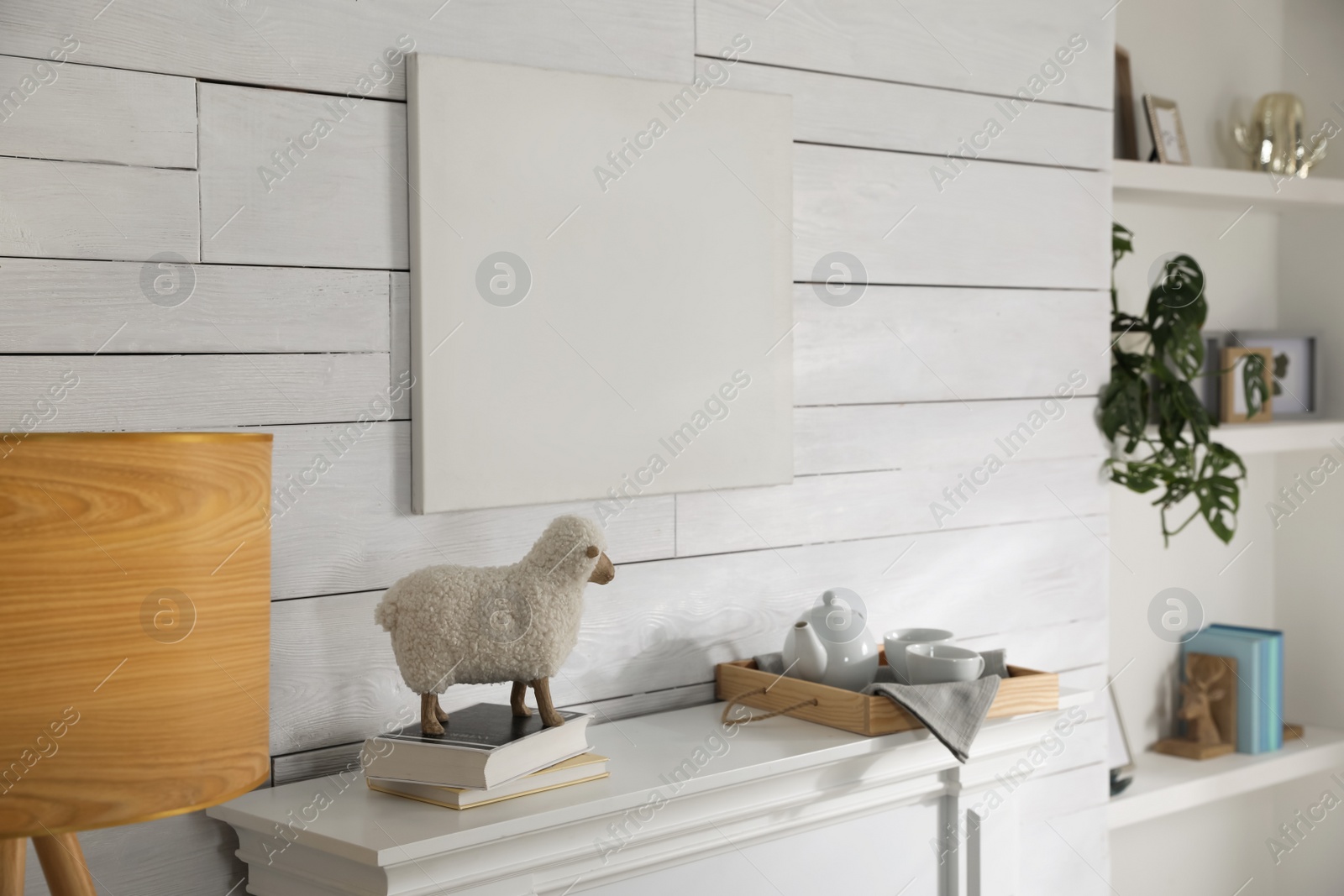 Photo of Stylish living room interior with empty canvas on white wooden wall. Mockup for design