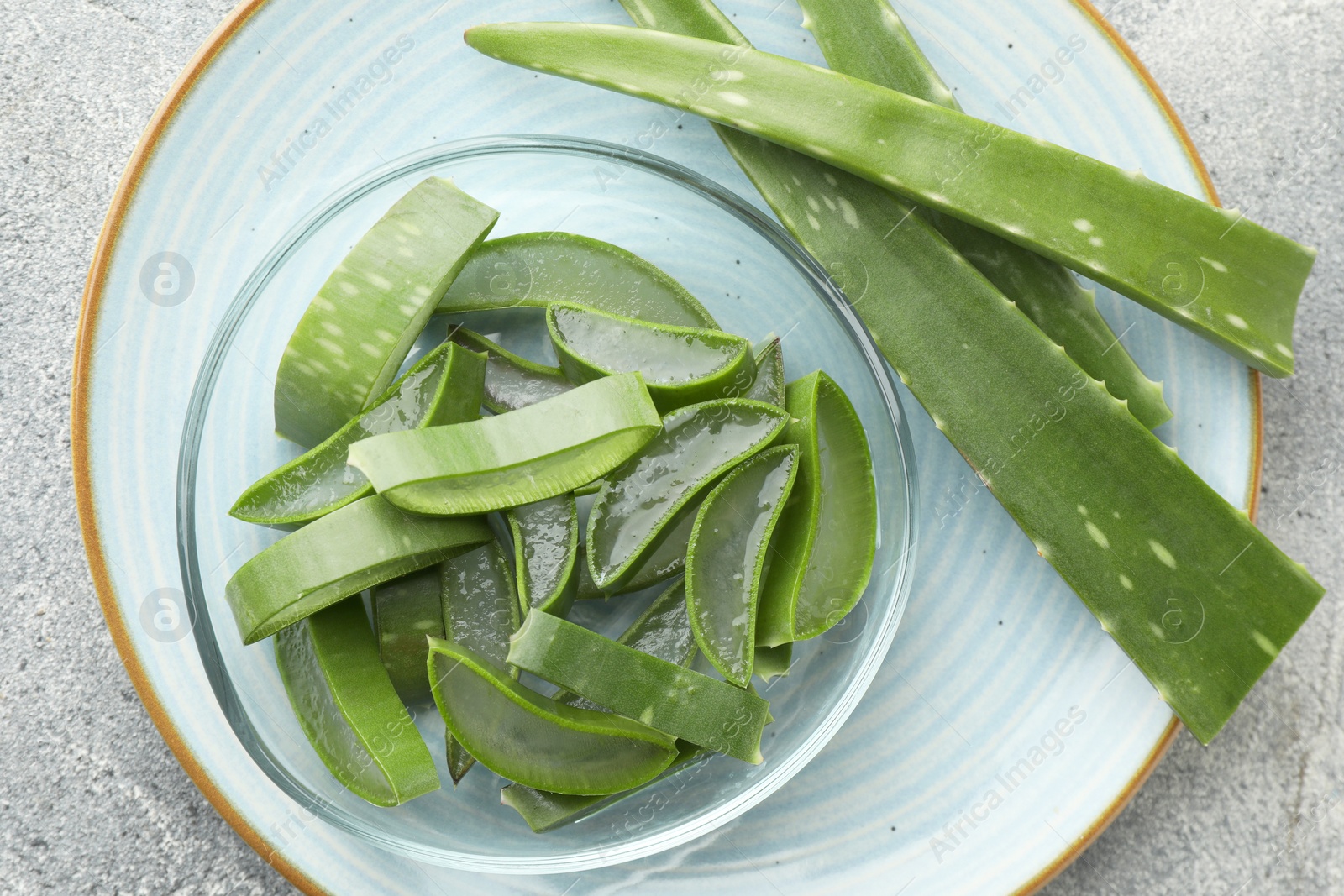 Photo of Fresh aloe vera pieces on light grey table, top view