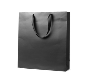 Photo of Paper shopping bag with ribbon handles on white background. Mockup for design