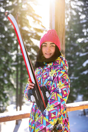 Photo of Young woman with ski wearing winter sport clothes in forest