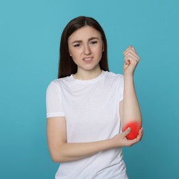 Woman suffering from rheumatism on light blue background