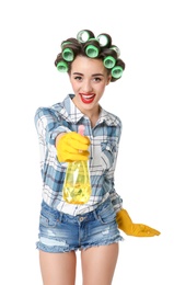 Photo of Funny young housewife with hair rollers holding detergent on white background