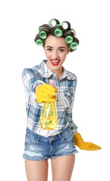 Funny young housewife with hair rollers holding detergent on white background