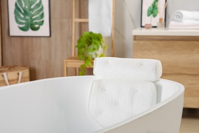 Photo of White tub with soft bath pillow indoors