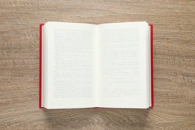 Photo of Open book on wooden table, top view