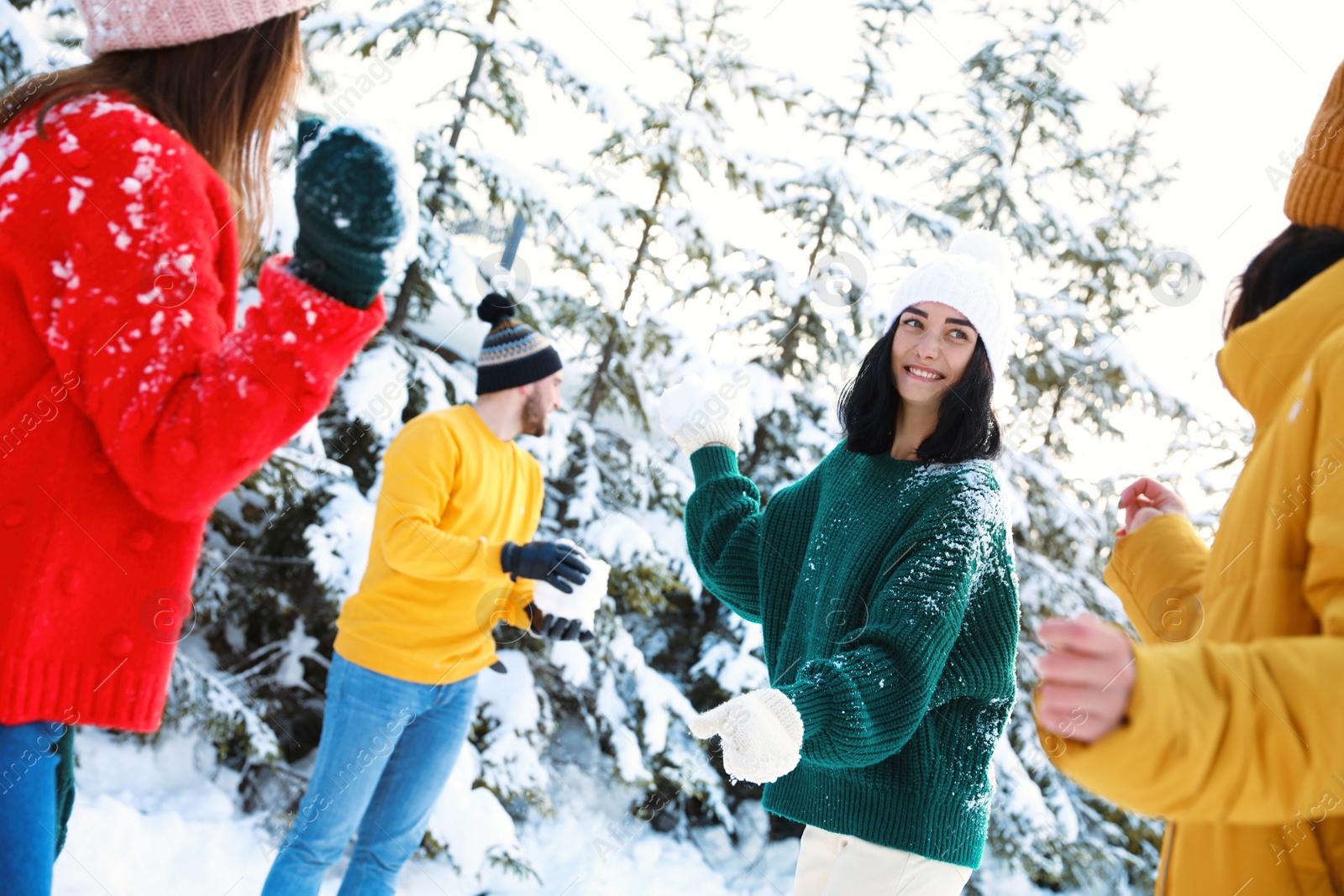 Photo of Happy friends playing snowballs outdoors. Winter vacation