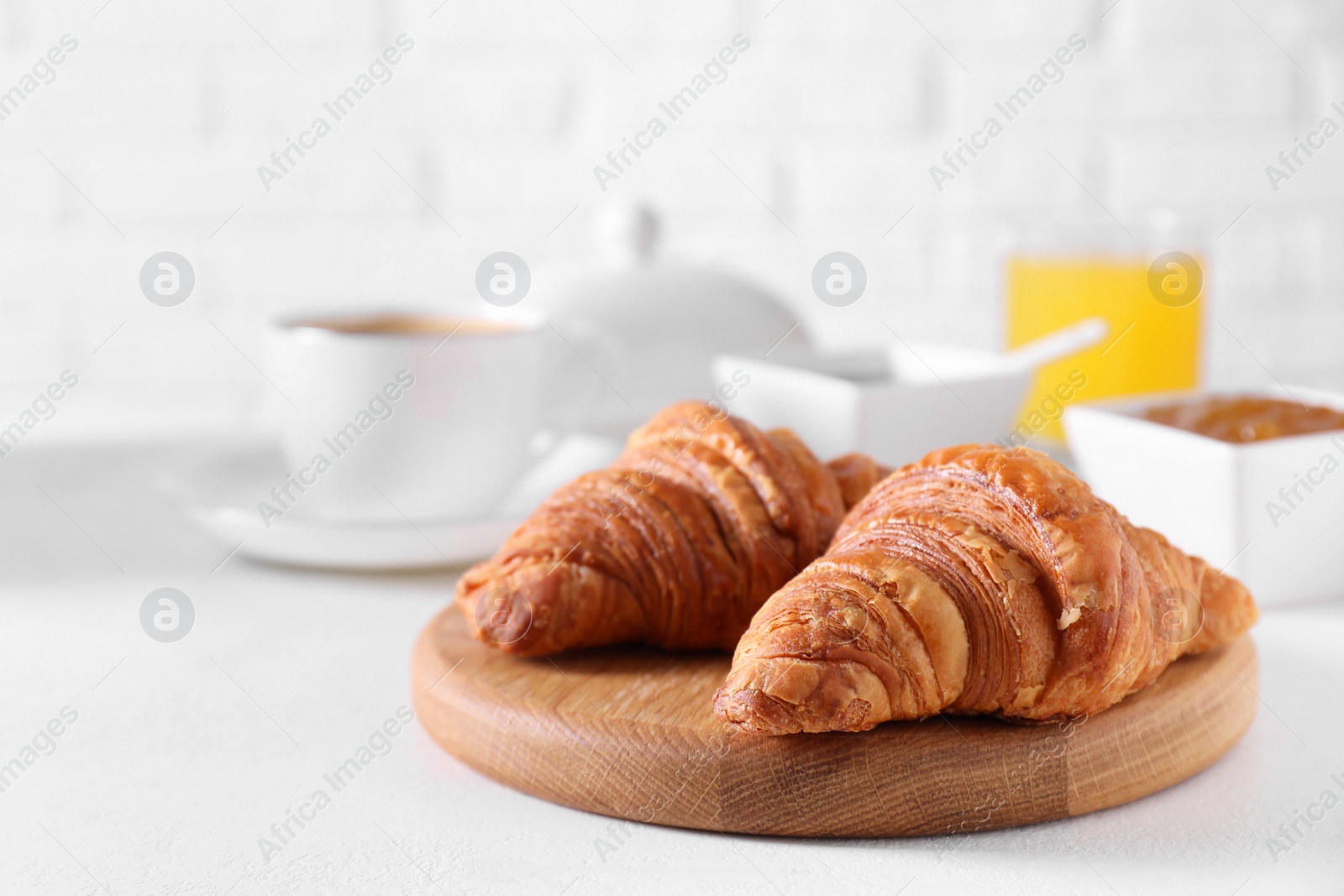 Photo of Fresh croissants on white table. Tasty breakfast