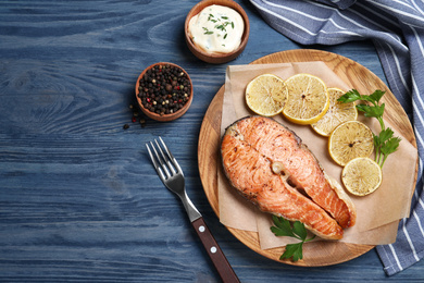 Photo of Flat lay composition with cooked red fish on blue wooden table