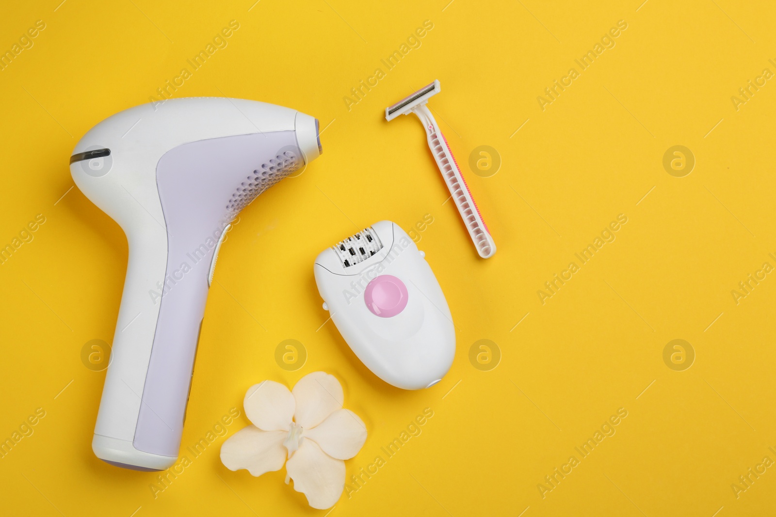 Image of Modern devices for epilation on yellow background, flat lay 